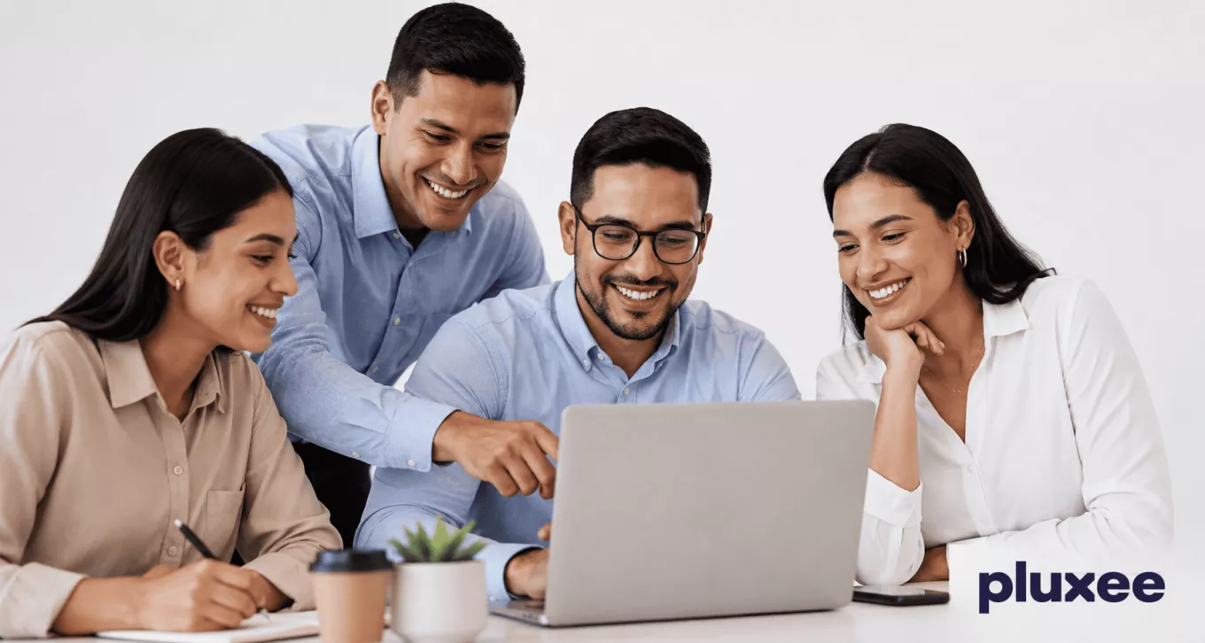 Equipo de trabajo colaborando frente a una laptop con actitud positiva y compromiso laboral